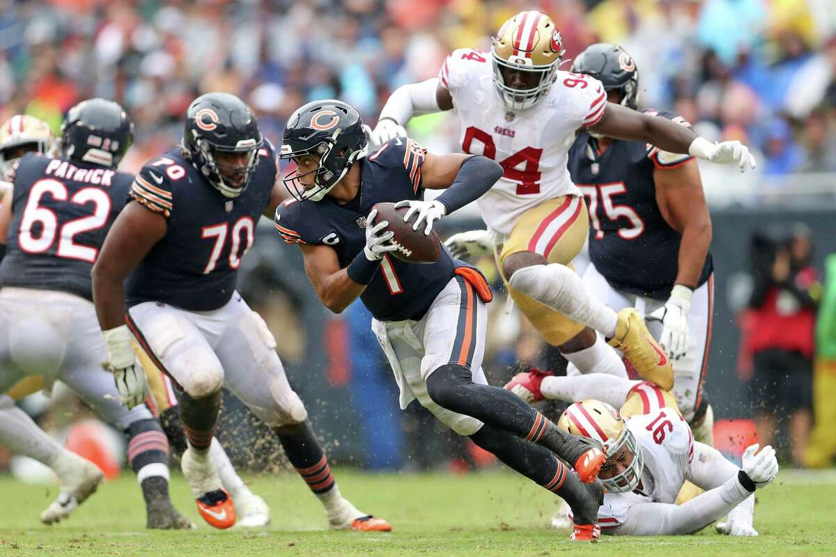 Chicago Bears’ Justin Fields scrambles away from San Francisco 49ers’ Arik Armstead and Charles Omenihu before throwing a 3rd quarter touchdown pass to Dante Pettis during Bears’ 19-10 win in NFL game at Soldier Field in Chicago, IL, on Sunday, September 11, 2022.