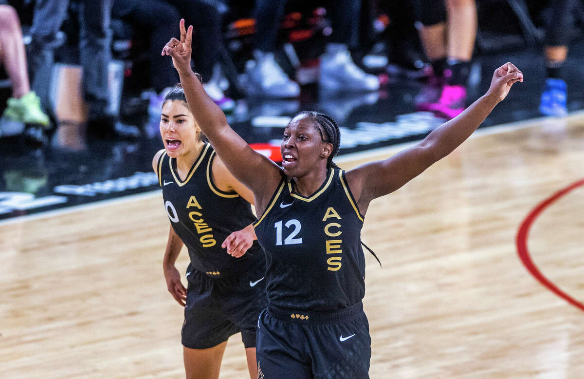 Las Vegas Aces guard Chelsea Gray (12) signals teammates with guard Kelsey Plum (10) nearby during the second half in Game 1 of a WNBA basketball final playoff series against the Connecticut Sun, Sunday, Sept. 11, 2022, in Las Vegas. (AP Photo/L.E. Baskow)