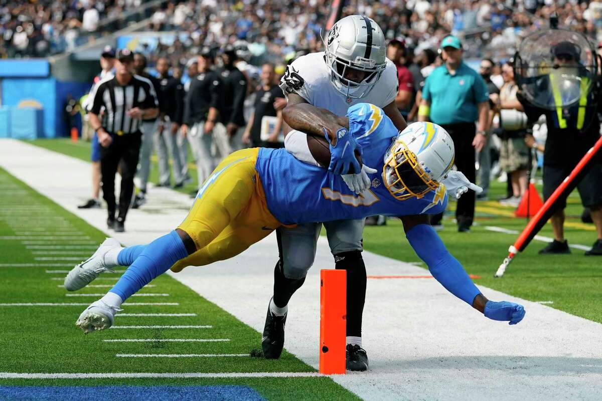 Chargers tight end Gerald Everett scores a touchdown against Raiders safety Roderic Teamer during the second half of Los Angeles’ home win.
