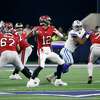 Tampa Bay Buccaneers quarterback Tom Brady (12) prepares to throw a pass as running back Leonard Fournette (7) helps against pressure from Dallas Cowboys linebacker Micah Parsons, second from right, in the second half of a NFL football game in Arlington, Texas, Sunday, Sept. 11, 2022.