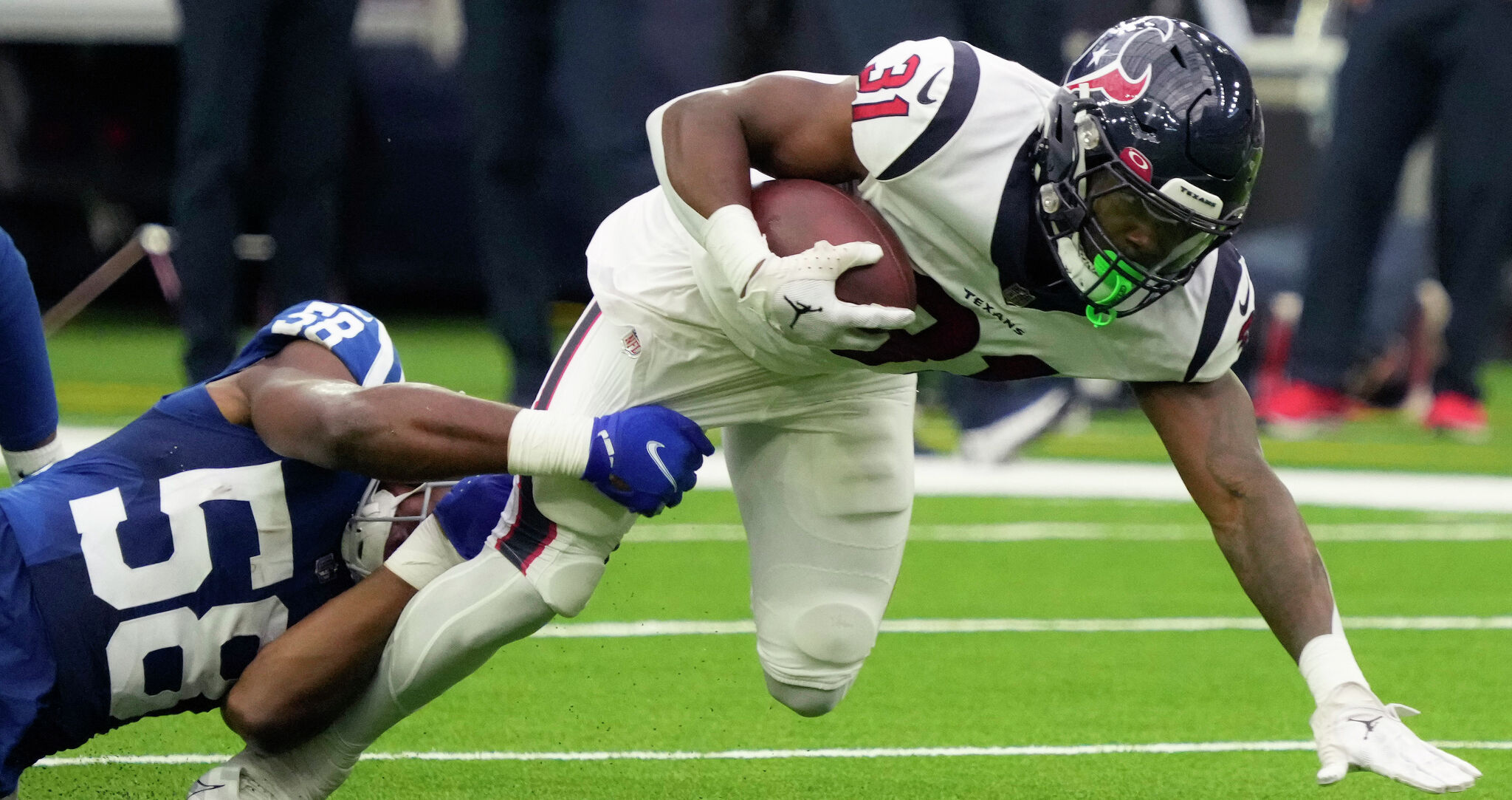 Indianapolis Colts running back Jonathan Taylor (28) tries to run away from  Houston Texans safety Jonathan Owens (36) the NFL football game between the  Indianapolis Colts and the Houston Texans on September