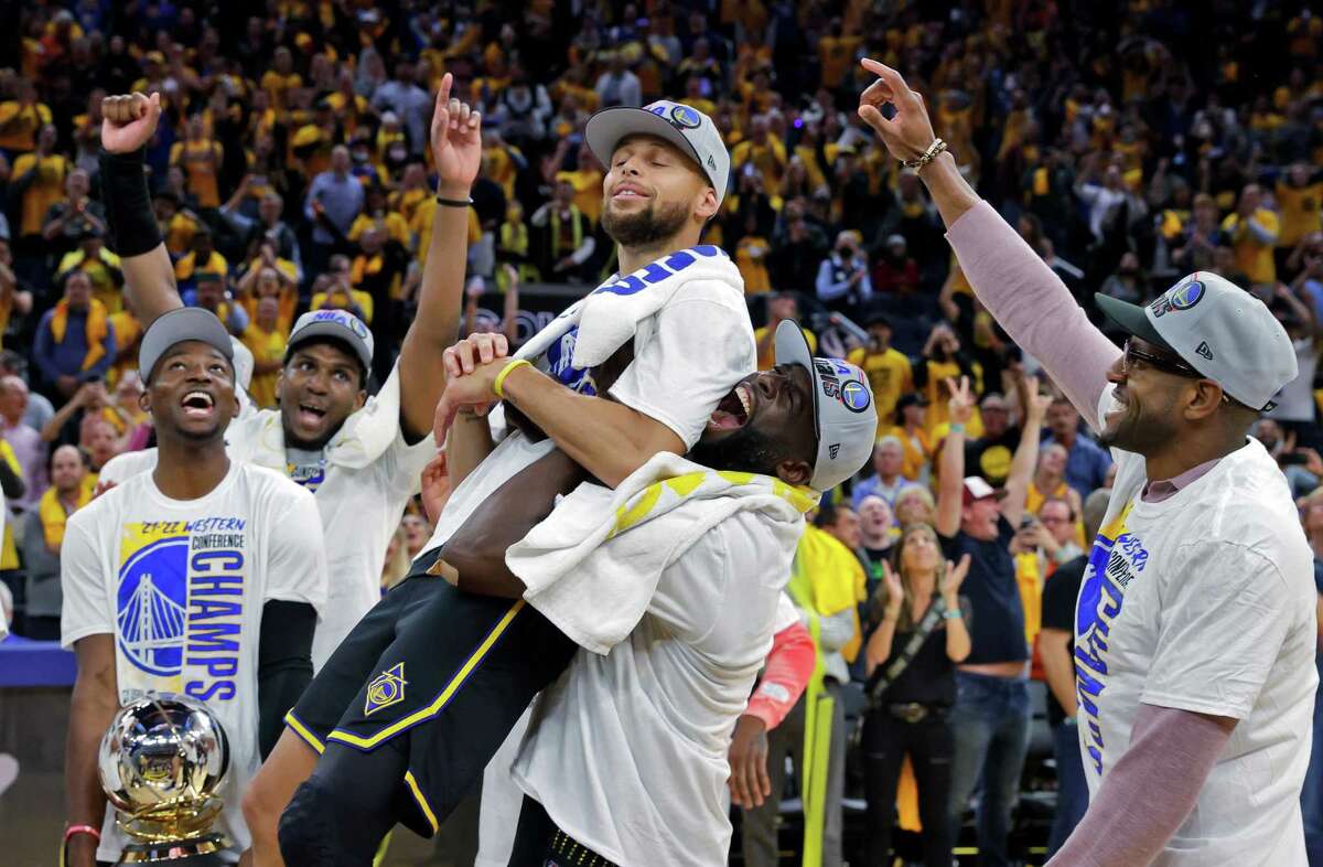 Draymond Green (23) lifts Stephen Curry (30) when it was announced he won the MVP for the Western Conference Finals after the Golden State Warriors defeated the Dallas Mavericks 120-110 in Game 5 of the Western Conference Finals to advance to the NBA Finals at Chase Center in San Francisco, Calif., on Thursday, May 26, 2022.