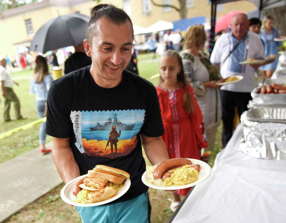 Stamford's Vitaliy Kuzmych loads two plates with kielbasa, saurkraut, holubtsi, and pyrohy at the Connecticut Ukrainian Festival at St. Basil's Seminary in Stamford, on Sunda. The 53rd annual event featured a Pontifical Divine Liturgy, Ukrainian songs and dancing, traditional food, Ukrainian vendors, and carnival rides.