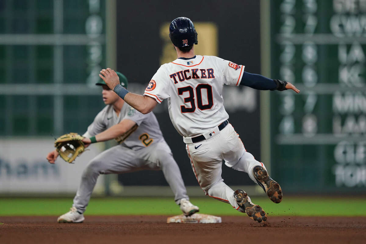 HOUSTON, TEXAS - AUGUST 13: Kyle Tucker #30 of the Houston Astros dives whilst attempting a steal of second base against the Oakland Athletics at Minute Maid Park on August 13, 2022 in Houston, Texas. (Photo by Alex Bierens de Haan/Getty Images)