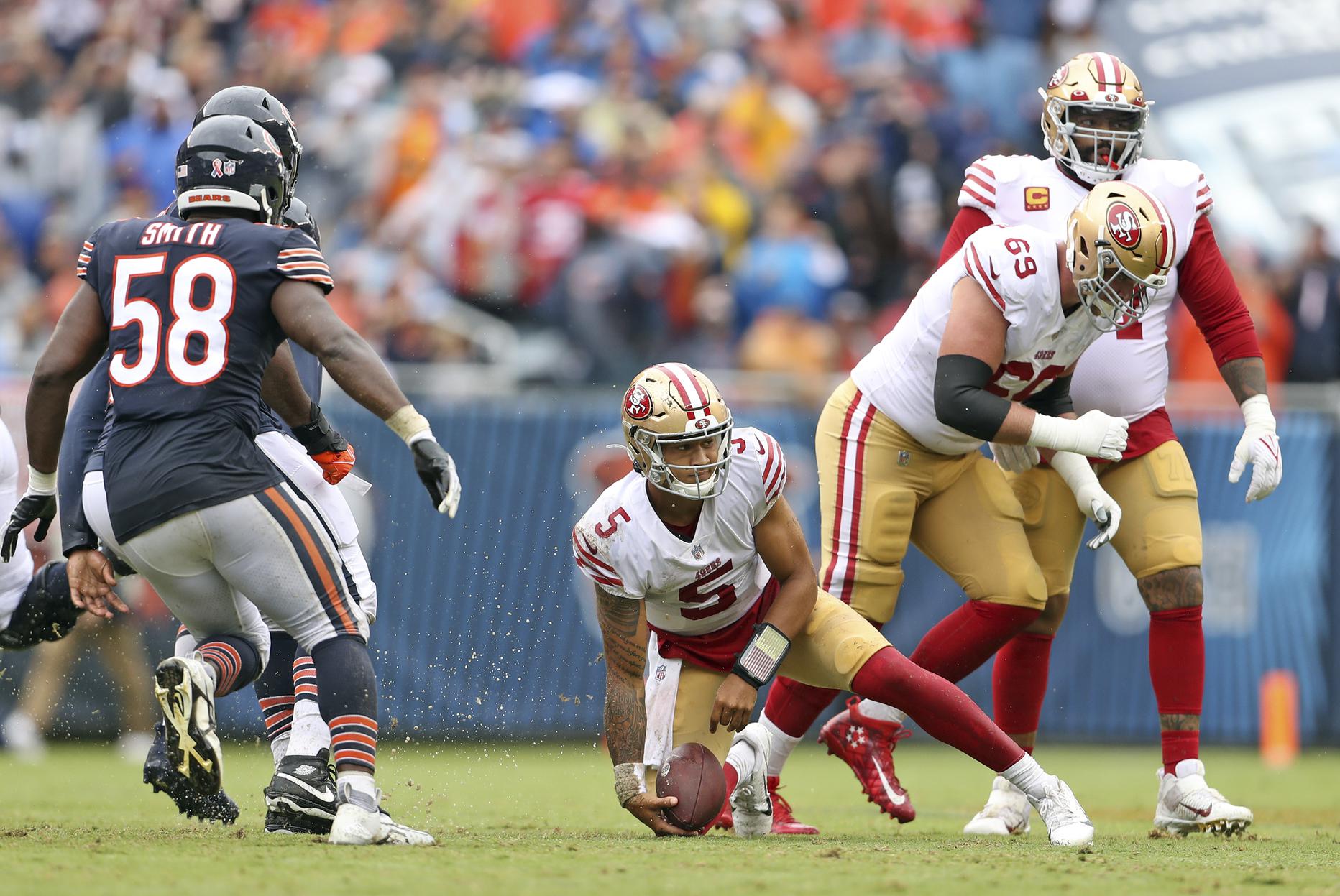 Quarterback Trey Lance of the San Francisco 49ers escapes a sack