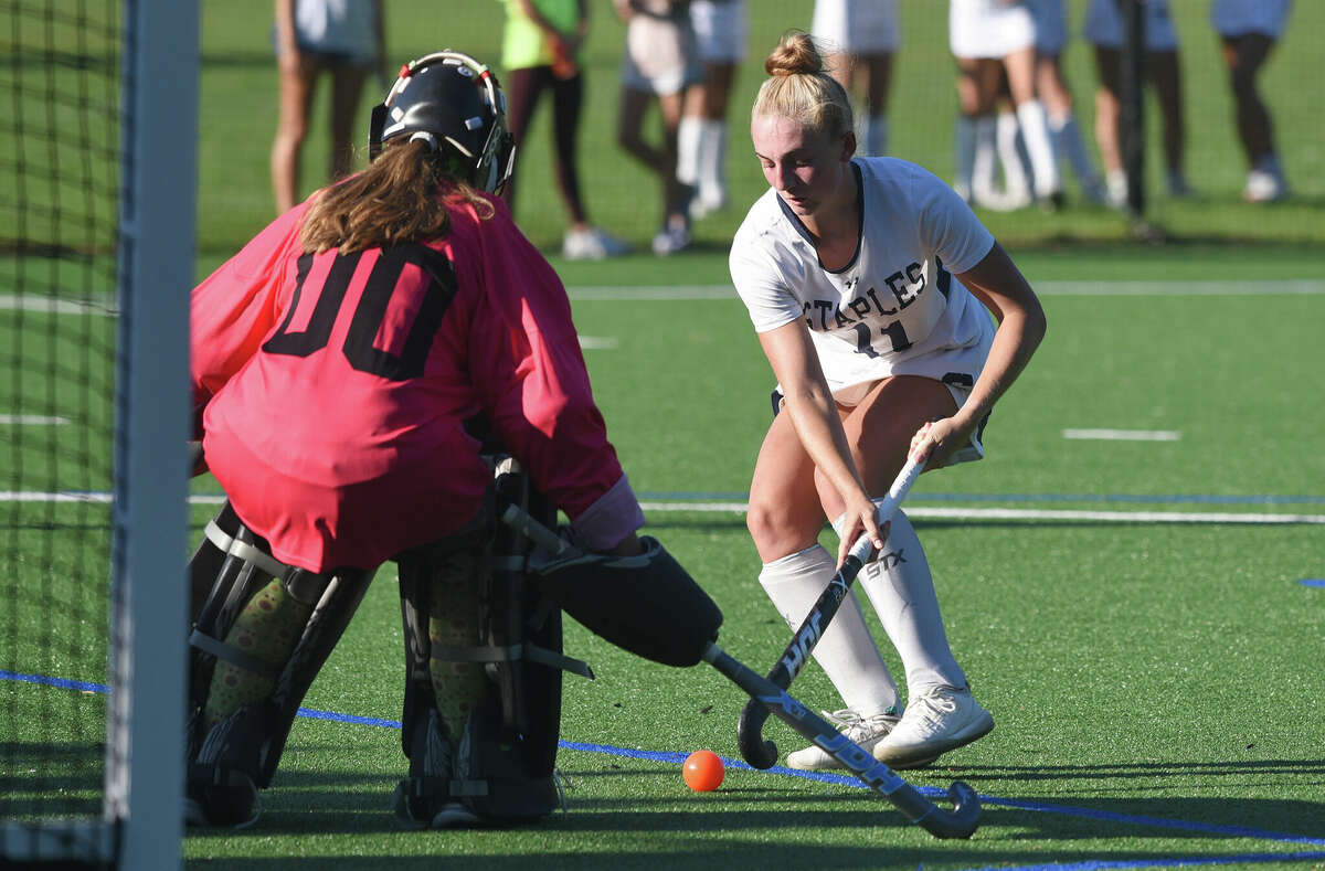 Staples' Francine Stevens (11) closes in on the gcage while New Canaan goalie Emma Rosen defends during a field hockey game in Westport on Monday, Sept. 12, 2022.