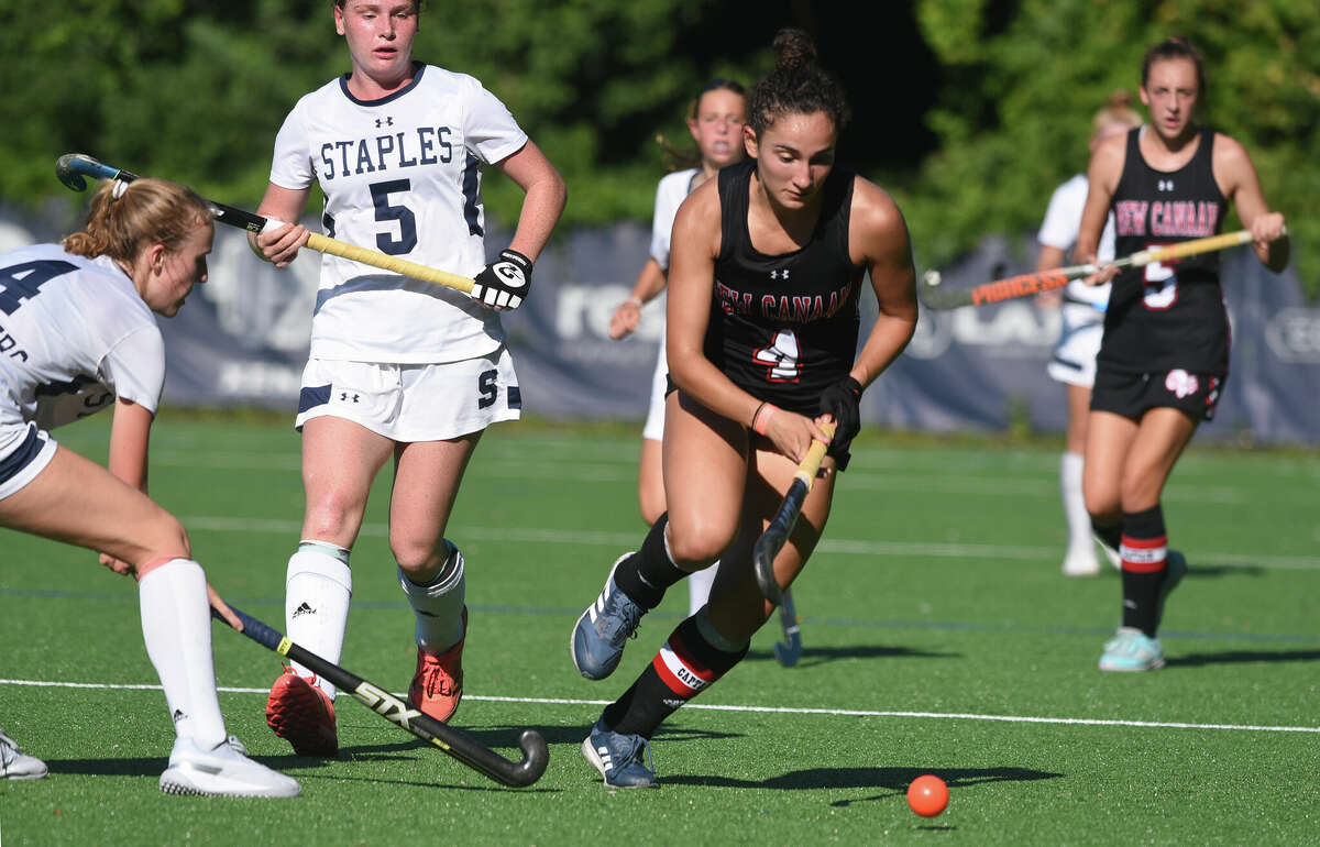 New Canaan's Shawna Ferraro (4) plays the ball in the midfield against Staples during a field hockey game in Westport on Monday, Sept. 12, 2022.