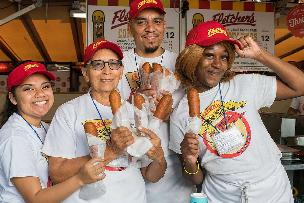 Workers at Fletcher's Corny Dogs show off their deep-fried wares at the State Fair of Texas in Dallas. The stall is one of the favorites of visitors to the fair.