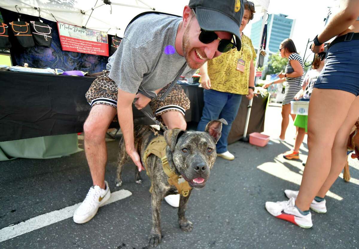 Matt Terry and hig dog Ella hang out and browse the different exhibits during the annual Arts & Crafts on Bedford event on Bedford Street in downtown Stamford, Conn., on Saturday September 10, 2022. Arts & Crafts on Bedford brings juried artisans from throughout the Northeast who will display and sell juried works including ceramics, fiber arts, fine art, jewelry, metal, photography, painting, wood and more. Arts & Crafts on Bedford is presented by Stamford Downtown Special Services District and sponsored by 95.9 The Fox, Star 99.9, WEBE 108 and Happyhaha.com Photography.