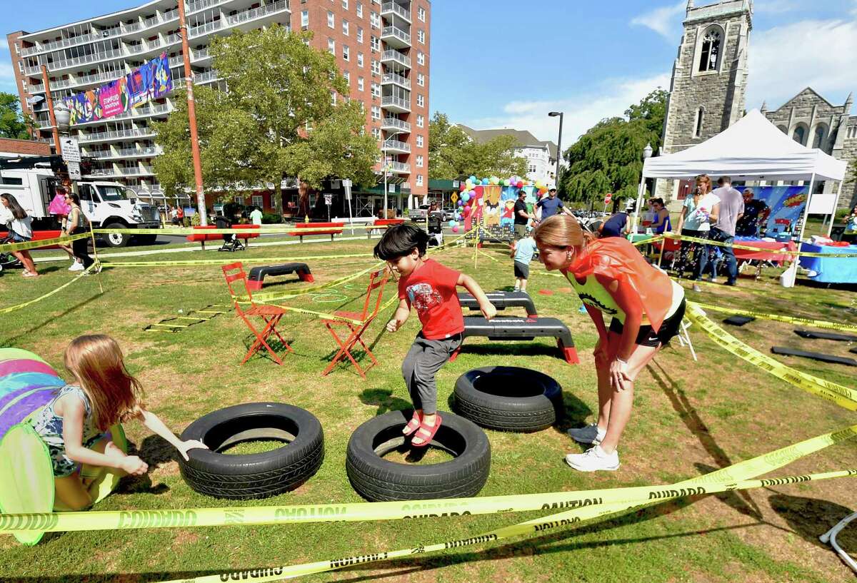 Viaan Abwani, 4, jumps through tires as part of Life Cycle's Superhero Obstacle Course at Latham Park during the annual Arts & Crafts on Bedford event on Bedford Street in downtown Stamford, Conn., on Saturday September 10, 2022. Arts & Crafts on Bedford brings juried artisans from throughout the Northeast who will display and sell juried works including ceramics, fiber arts, fine art, jewelry, metal, photography, painting, wood and more. Arts & Crafts on Bedford is presented by Stamford Downtown Special Services District and sponsored by 95.9 The Fox, Star 99.9, WEBE 108 and Happyhaha.com Photography.