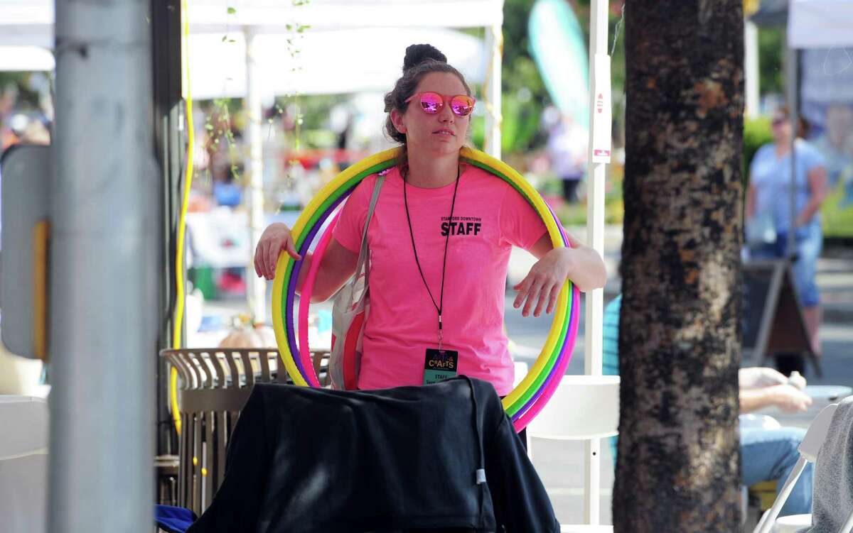 Staffer Kate Cook holds hula hoops before heading over to Latham Park for the kids entertainment during the annual Arts & Crafts on Bedford event on Bedford Street in downtown Stamford, Conn., on Saturday September 10, 2022. Arts & Crafts on Bedford brings juried artisans from throughout the Northeast who will display and sell juried works including ceramics, fiber arts, fine art, jewelry, metal, photography, painting, wood and more. Arts & Crafts on Bedford is presented by Stamford Downtown Special Services District and sponsored by 95.9 The Fox, Star 99.9, WEBE 108 and Happyhaha.com Photography.
