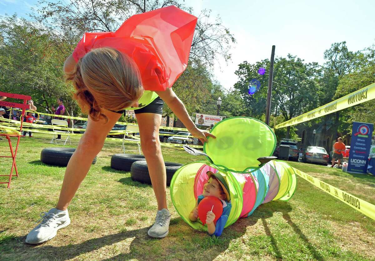 Suren Zamani, 3, peeks out from the crawl tube he is hiding in while trying to complete Life Cycle's Superhero Obstacle Course at Latham Park during the annual Arts & Crafts on Bedford event on Bedford Street in downtown Stamford, Conn., on Saturday September 10, 2022. Arts & Crafts on Bedford brings juried artisans from throughout the Northeast who will display and sell juried works including ceramics, fiber arts, fine art, jewelry, metal, photography, painting, wood and more. Arts & Crafts on Bedford is presented by Stamford Downtown Special Services District and sponsored by 95.9 The Fox, Star 99.9, WEBE 108 and Happyhaha.com Photography.