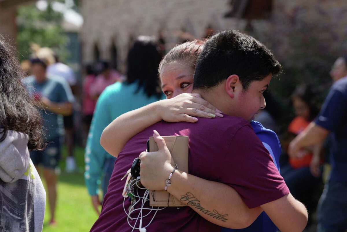 Francisco Madrid, a ninth-grader at Heights High School, is reunited with his mother, Adriana Ordaz, Tuesday, Sept. 13, 2022, near Heights High School in Houston.