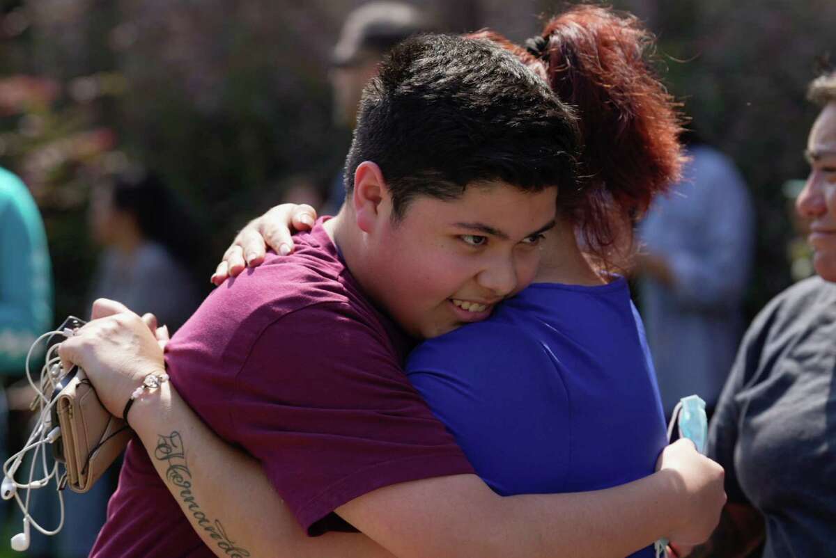 Francisco Madrid, a ninth-grader at Heights High School, is reunited with his mother, Adriana Ordaz, Tuesday, Sept. 13, 2022, near Heights High School in Houston.