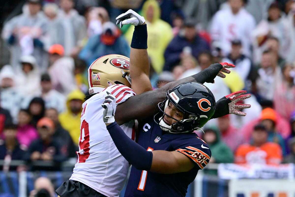 CHICAGO, ILLINOIS - SEPTEMBER 11: Justin Fields #1 of the Chicago Bears is hit by Javon Kinlaw #99 of the San Francisco 49ers after passes the football in the first quarter at Soldier Field on September 11, 2022 in Chicago, Illinois. (Photo by Quinn Harris/Getty Images)