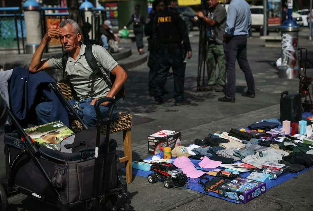 小贩Efrain Carranza和他的货物在一起，警方向他提供了如何获得卖方许可证的信息。bwin登入