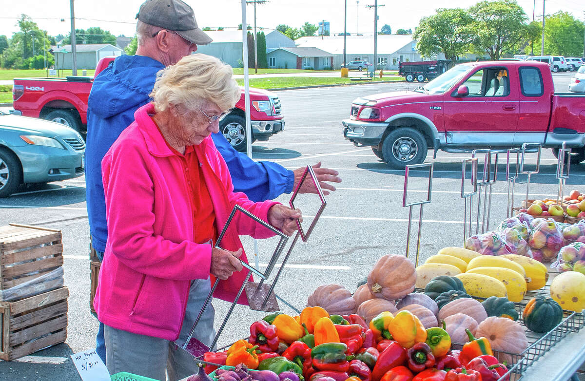 Shirley Gregory (front) and John Sampson of Gregory's Orchard and Gardens in Lynnville break down their produce display during the Jacksonville Farmer's Market.