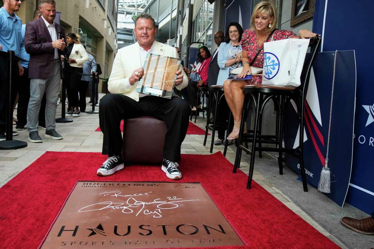 Roger Clemens, with his wife, Debbie, sits down and poses for photos after getting the first look at his walk of fame plaque during the Ring Ceremony and Walk of Fame Unveiling for the Houston Sports Hall of Fame Class of 2022 Tuesday, Sept. 13, 2022 in Houston.