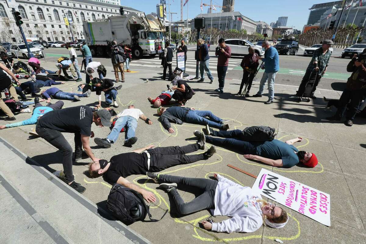Participants at an HIV rally performed a “die-in” on the steps of San Francisco City Hall in March. The rally was organized around re-prioritizing HIV care after testing and treatment slipped during the pandemic — findings supported by San Francisco’s annual HIV report released Tuesday.