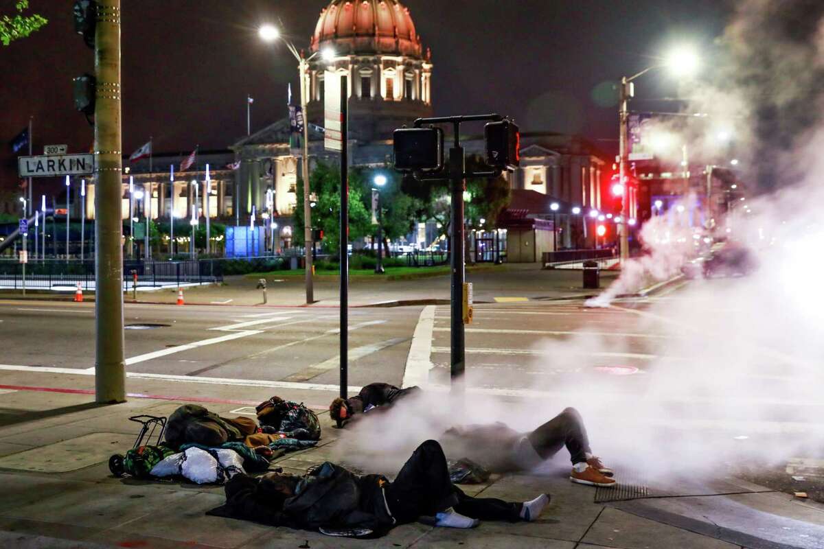 Four homeless men sleep on Larkin Street in San Francisco, California, on June 18, 2019.
