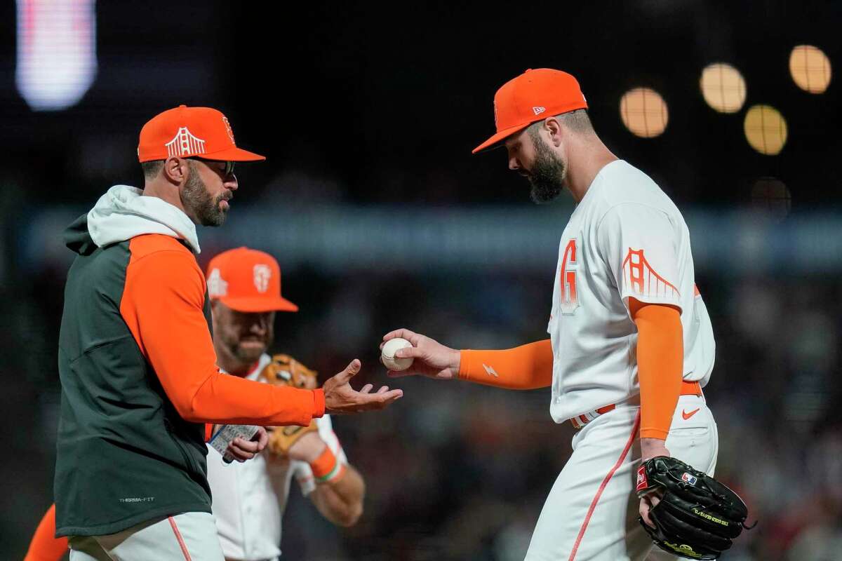 San Francisco Giants starting pitcher Jakob Junis, right, is pulled from the team's baseball game against the Atlanta Braves by manager Gabe Kapler during the sixth inning in San Francisco, Tuesday, Sept. 13, 2022. (AP Photo/Godofredo A. Vásquez)