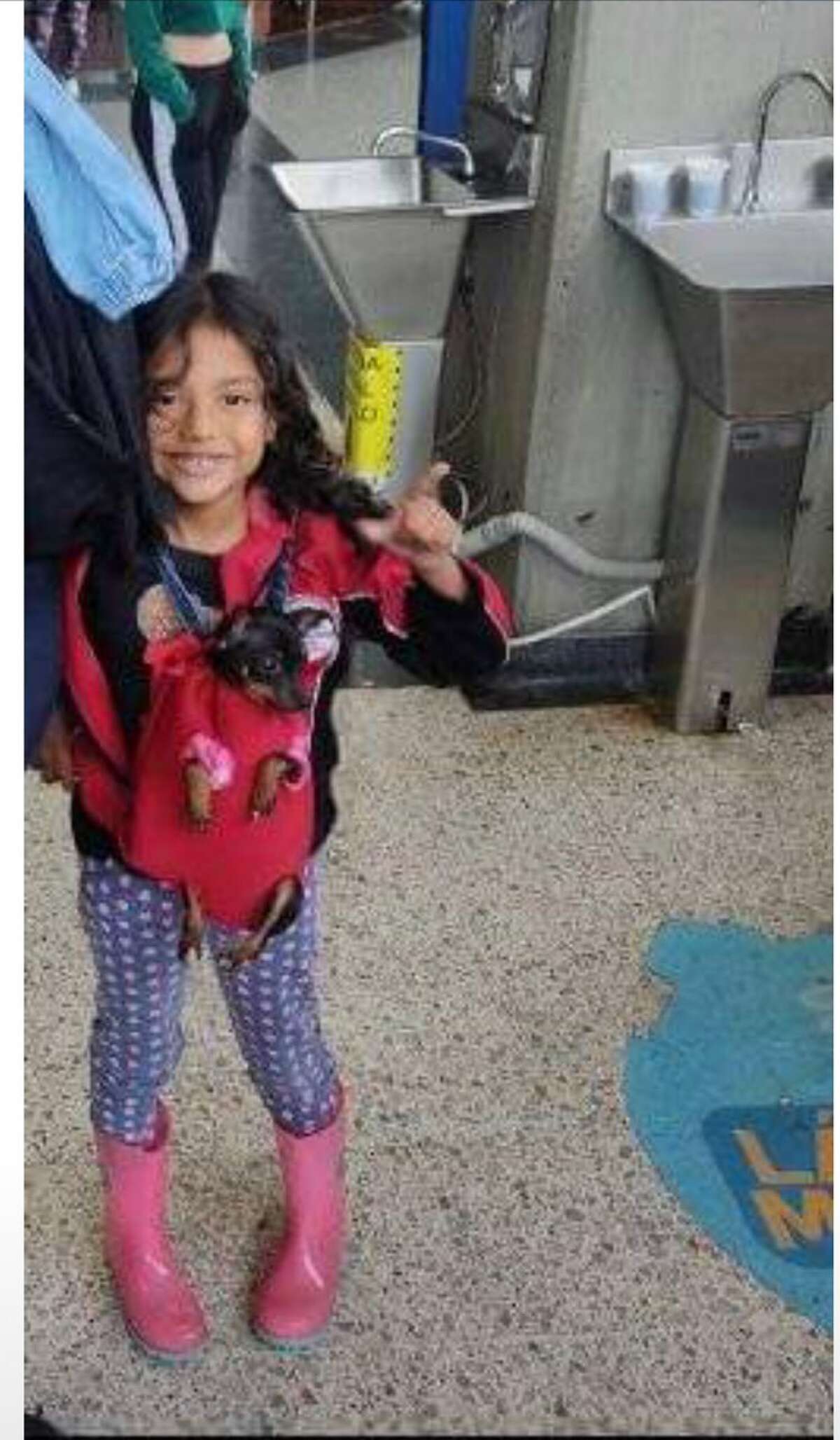 Pictured is the De Los Campos family's 5-year-old daughter with her dog, Fluke, before their trip from Venezuela to the United States. 