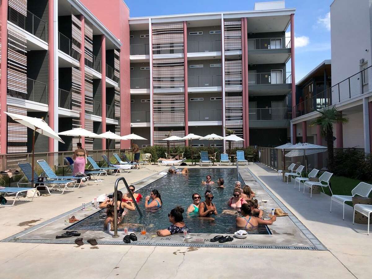Guests enjoy the 40-foot courtyard pool at East Austin Hotel in Austin, Texas. Even people who aren't staying at the hotel can buy day passes to lounge in the water and use a deck chair there.