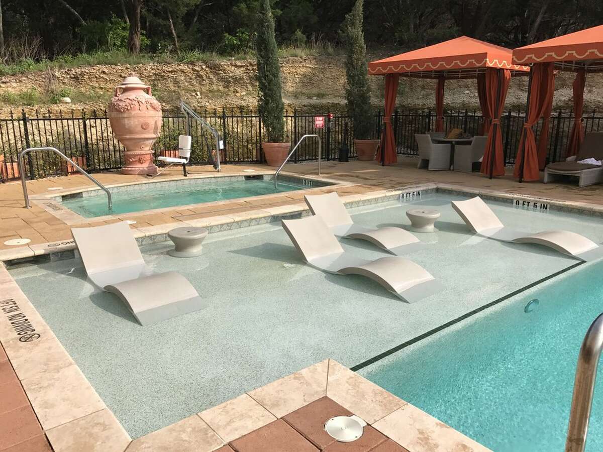In-water lounge chairs are shown in the courtyard pool area at Hotel Granduca, located just outside Austin, Texas.