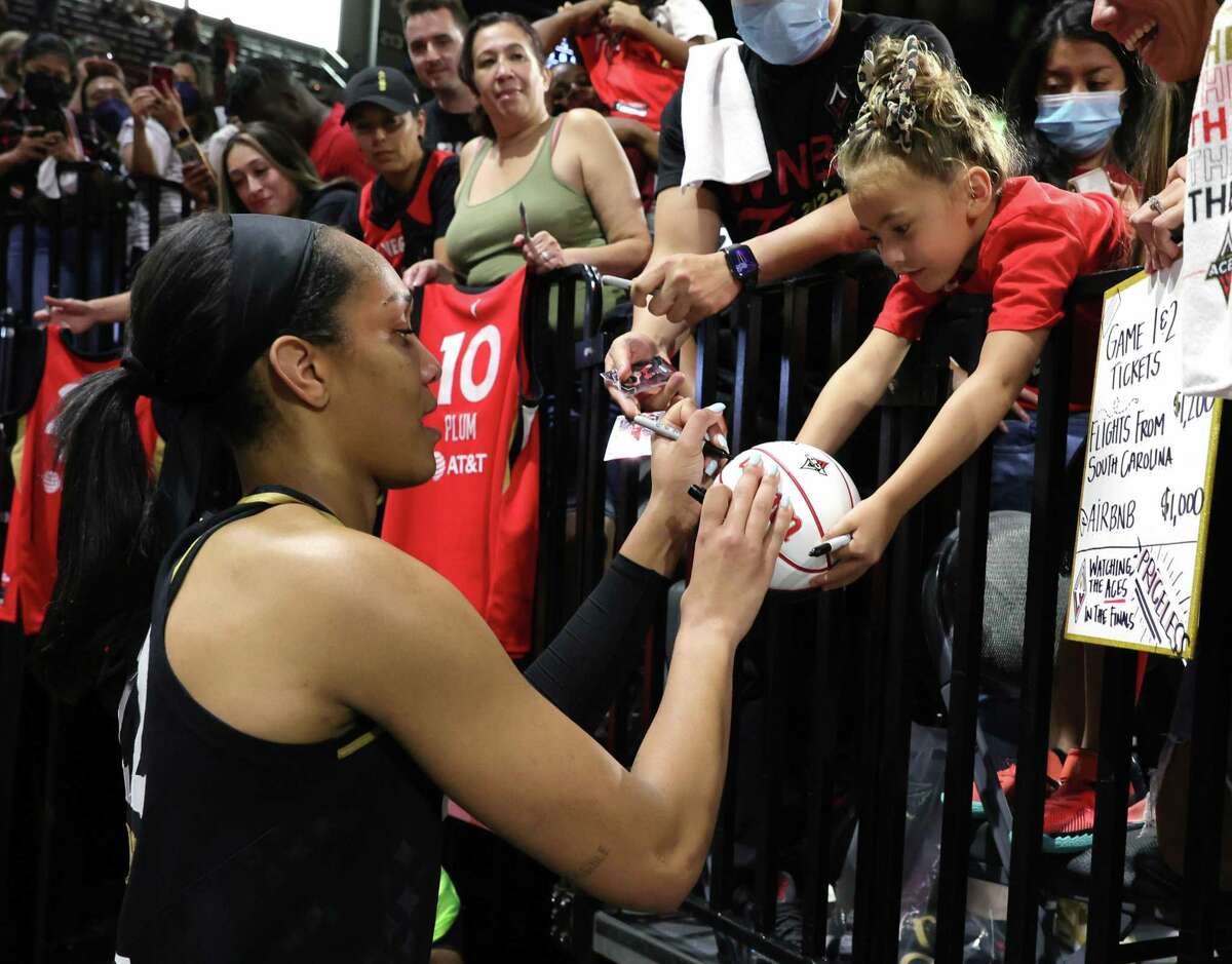 LAS VEGAS, NEVADA - SEPTEMBER 13: A'ja Wilson #22 of the Las Vegas Aces signs an autograph for Layne Thompson, 5, of South Carolina after the Aces' 85-71 victory over the Connecticut Sun to win Game Two of the 2022 WNBA Playoffs finals at Michelob ULTRA Arena on September 13, 2022 in Las Vegas, Nevada. NOTE TO USER: User expressly acknowledges and agrees that, by downloading and or using this photograph, User is consenting to the terms and conditions of the Getty Images License Agreement. (Photo by Ethan Miller/Getty Images)