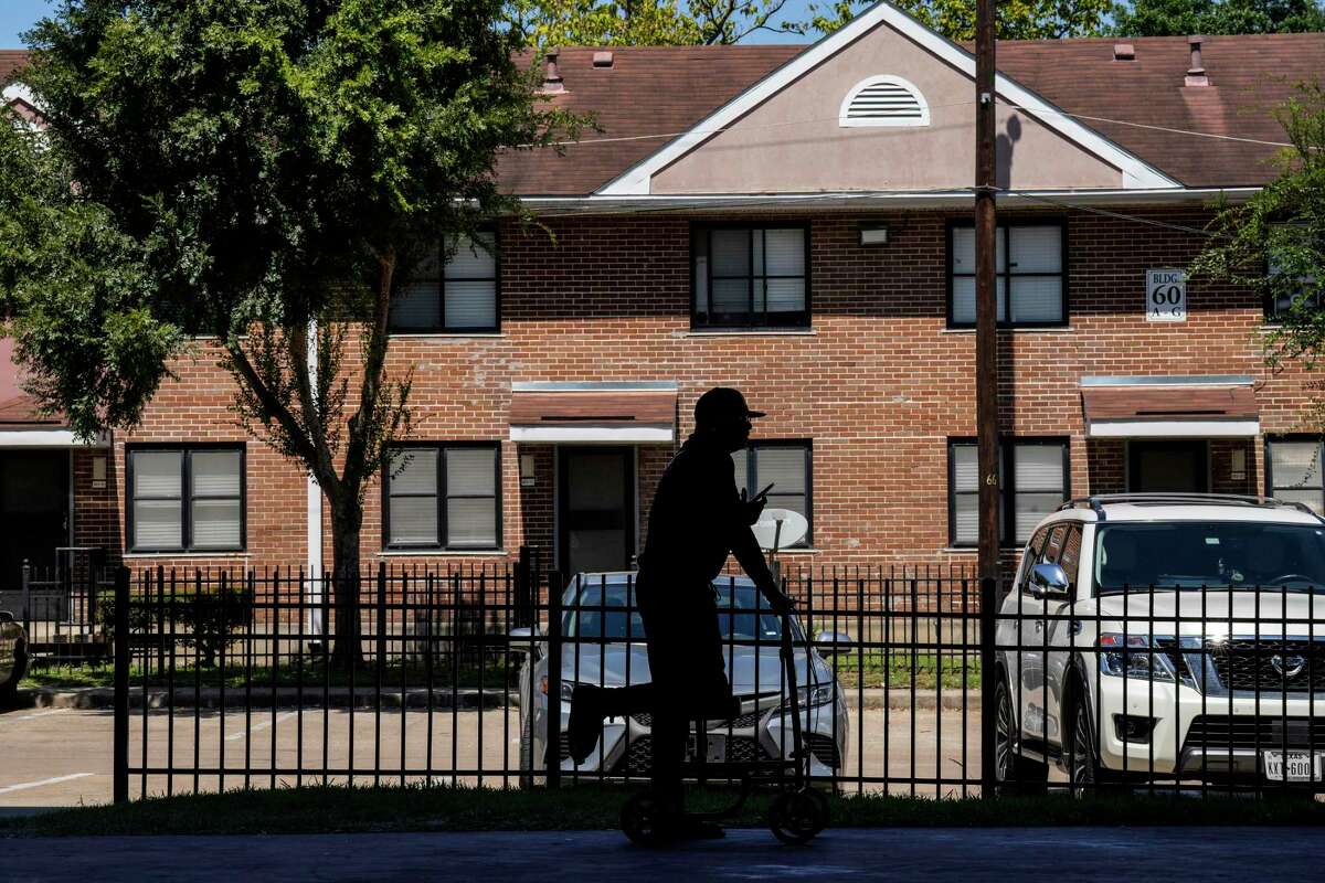 A resident stands on the basketball court watching a news conference at Cuney Homes on Wednesday, Sept. 14, 2022 in Houston. The waiting list to live at Cuney Homes will open Jan. 15.