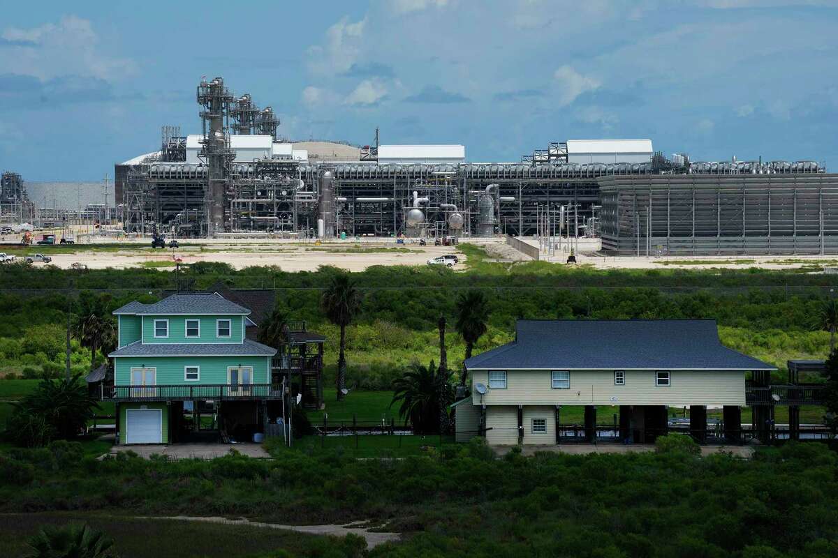 Residential properties with an LNG plant on the background, Sunday, Aug. 28, 2022, in Quintana.