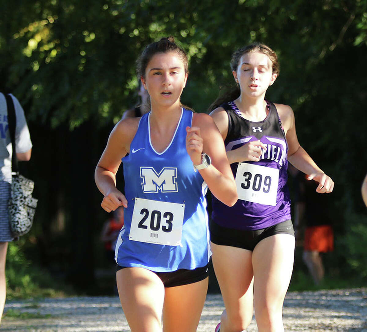 Marquette Catholic's Katie Johnson (left) runs during the Carlinville Early Meet earlier this season. On Wednesday, Johnson finished 15th to lead the Explorers at the Collinsville Invite.