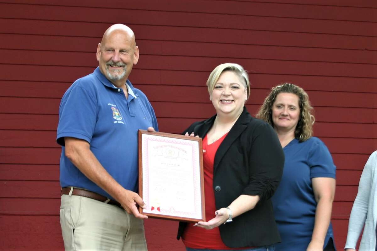 Senator Curt VanderWall visits Evart to pay tribute to their sesquicentennial year, presenting city officials with a plaque of recognition. VanderWall presents the plaque to Evart mayor Chris Emerick (center) with city manager Pepper Lockhart (right).