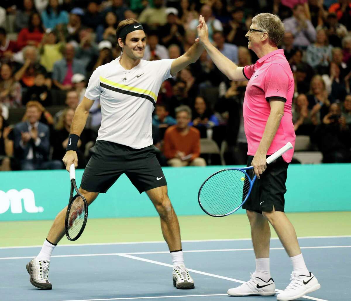 Roger Federer and Bill Gates high five while defeating Jack Sock and Savannah Guthrie during the pro/celebrity doubles tennis match during The Match for Africa at the SAP Center in San Jose, Calif., on Monday, March 5, 2018.