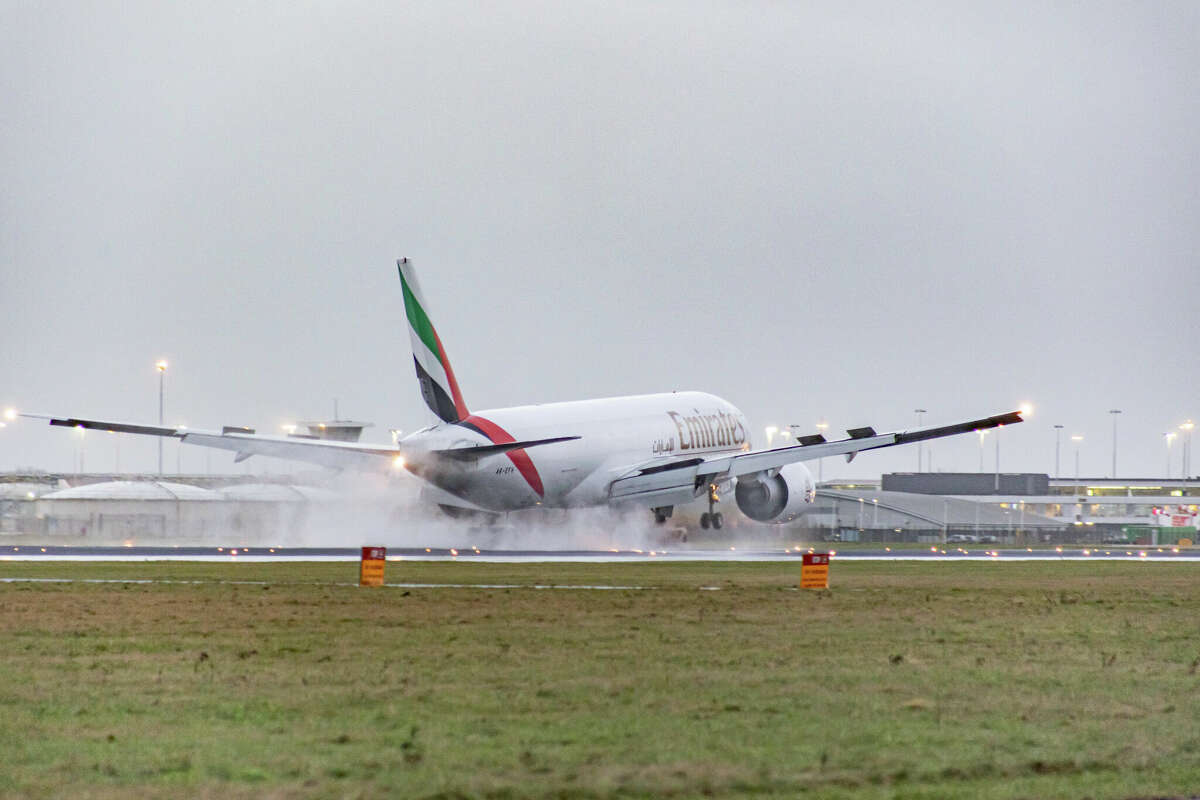 Emirates SkyCargo airline Boeing 777F aircraft in the Netherlands during a rainy evening.