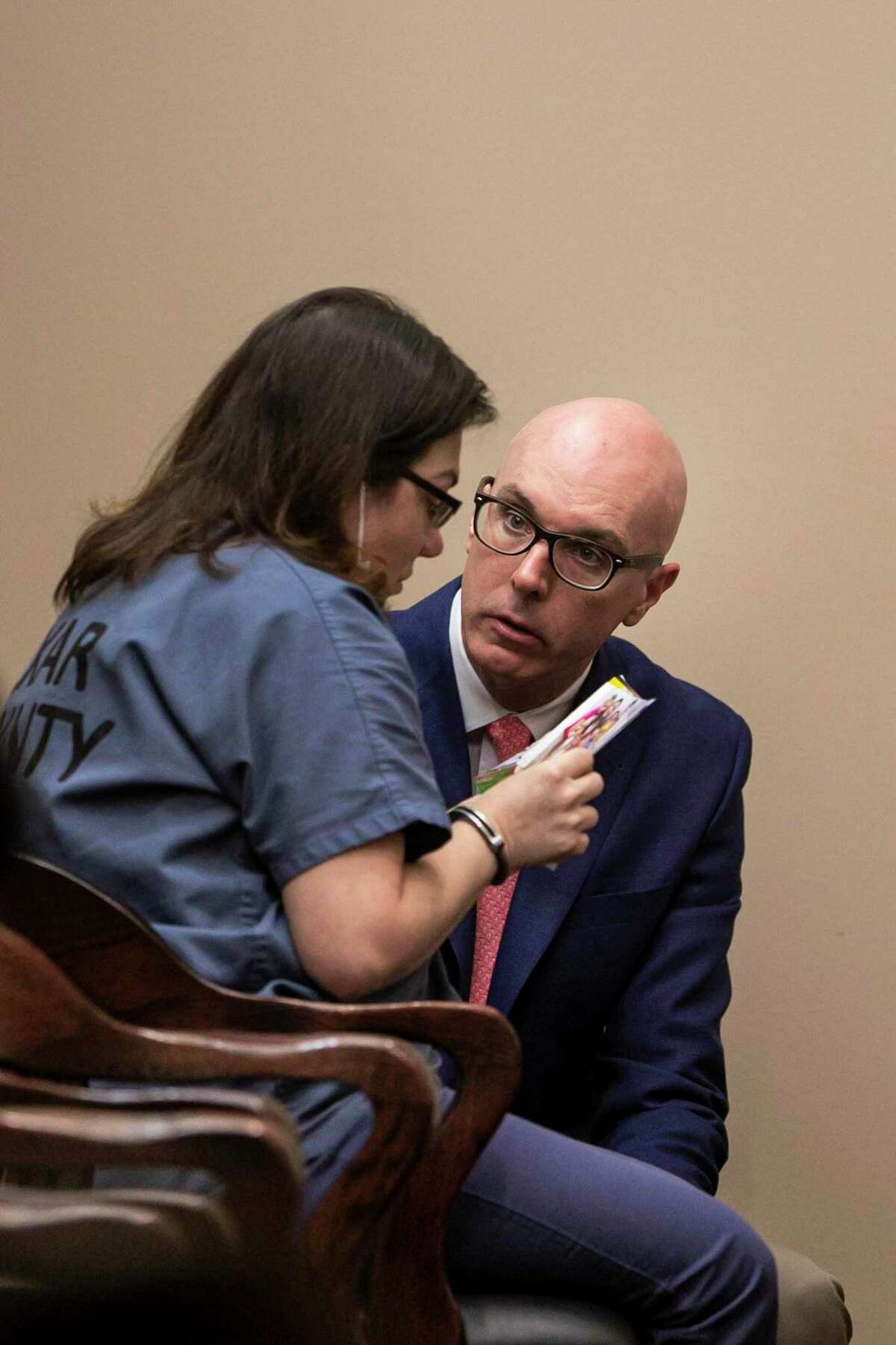 Defense attorney John Kuntz confers with client Krystal Margaret Jessica Rodriguez as she looks at family photos during her sentencing Thursday in the 399th District Court . She pleaded guilty to murder for fatally shooting her ex-husband, Jared Rodriguez, in December.