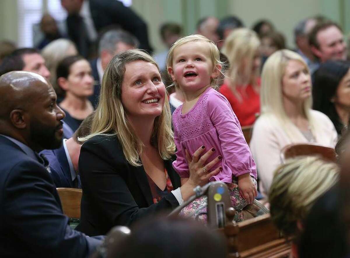 文件- 2018年12月3日星期一，加利福尼亚州萨克拉门托的立法会议期间，民主党女议员巴菲·威克斯和她2岁的女儿约瑟芬仰望着议会画廊。州长加文·纽森于2022年9月15日星期四说，加利福尼亚州将成为第一个要求提供吸引儿童的在线服务的公司将儿童利益放在首位的州。(美联社图片/Rich Pedroncelli, File)