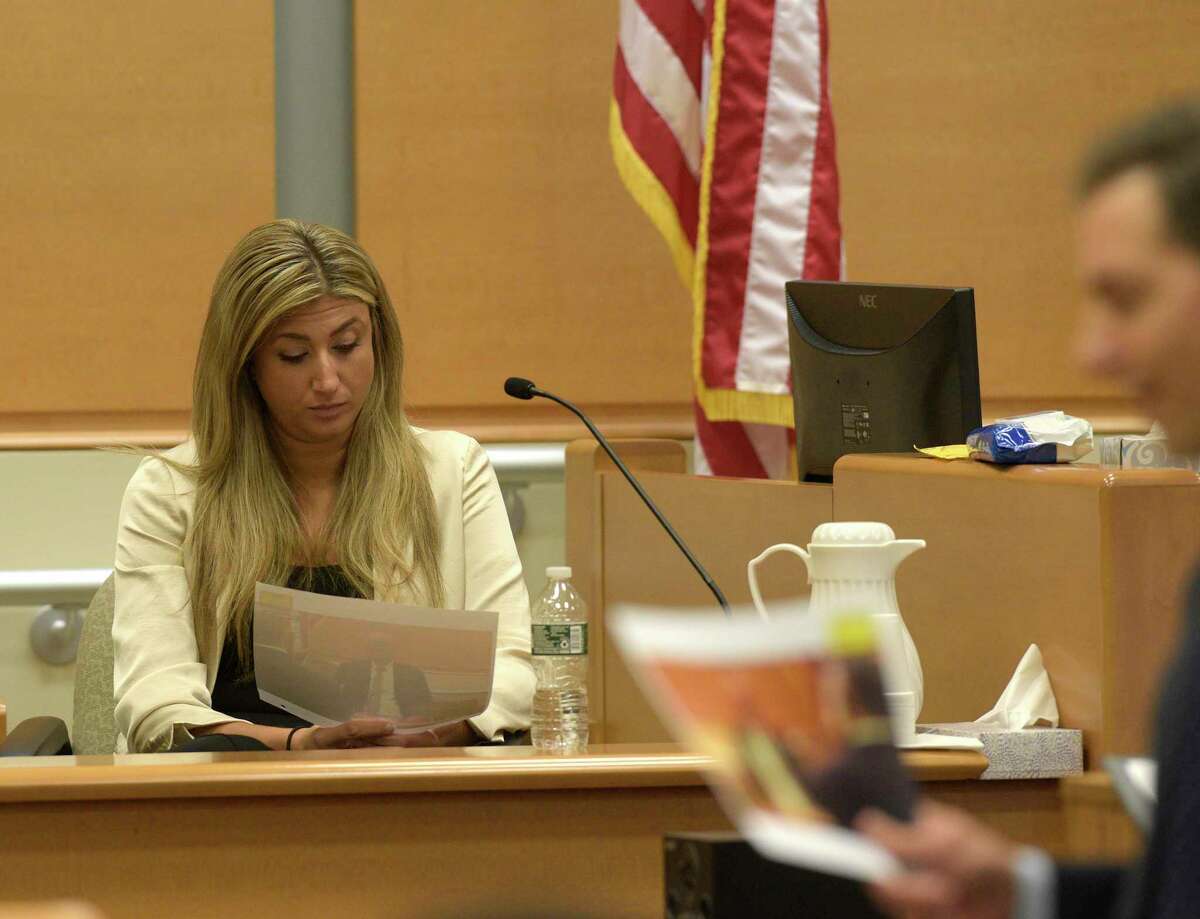 Brittany Paz, the corporate representative for Infowars, reviews a photograph handed to her by the plaintiff’s attorney Chris Mattei during the Alex Jones Sandy Hook defamation damages trial in Superior Court in Waterbury on Friday, September 16, 2022, Waterbury, Conn. H John Voorhees III / Hearst Connecticut Media.