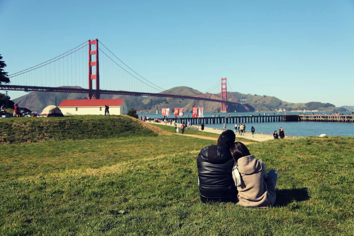 Casal apreciando a vista da ponte Golden Gate.