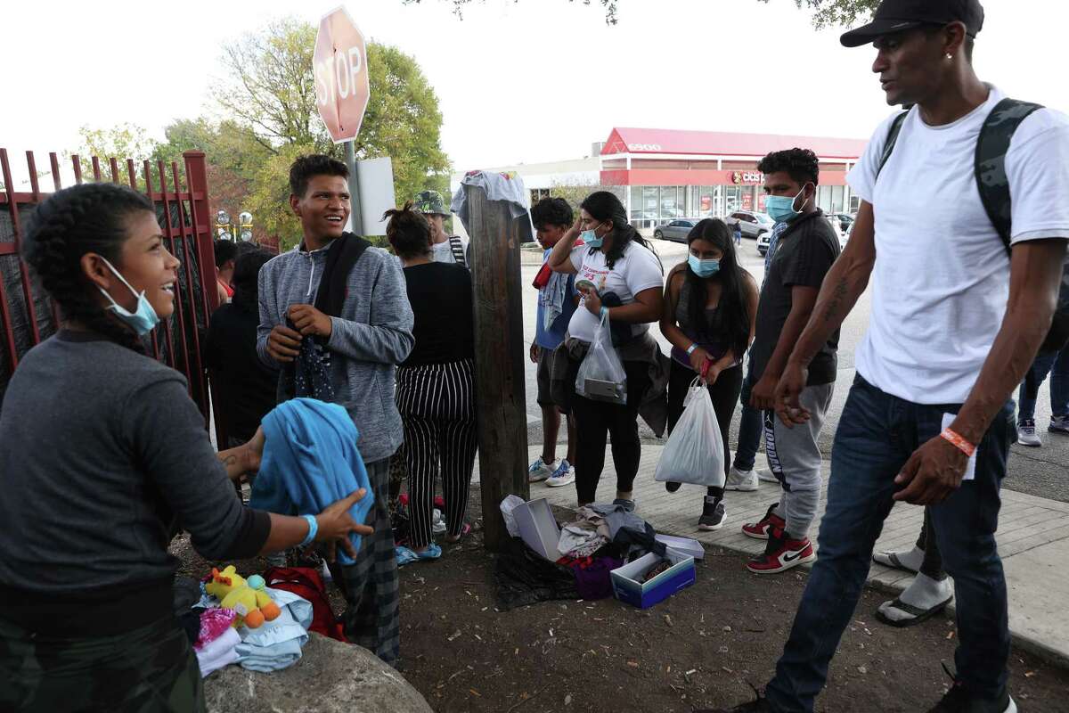 Migrants sort through clothing outside the San Antonio Migrant Resource Center on San Pedro Avenue. Most migrants were sheltered at the center in hopes of getting a ticket to other parts of the country by air or bus.