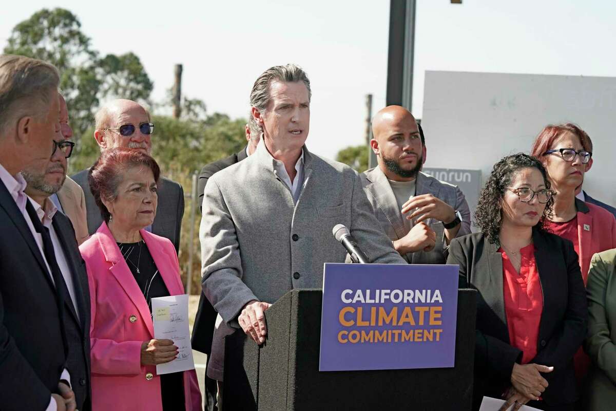 Gov. Gavin Newsom, center, flanked by state lawmakers, discusses legislation he signed that accelerates the climate goals of the nation's most populous state, at Mare Island in Vallejo, Calif., on Sept. 16, 2022.