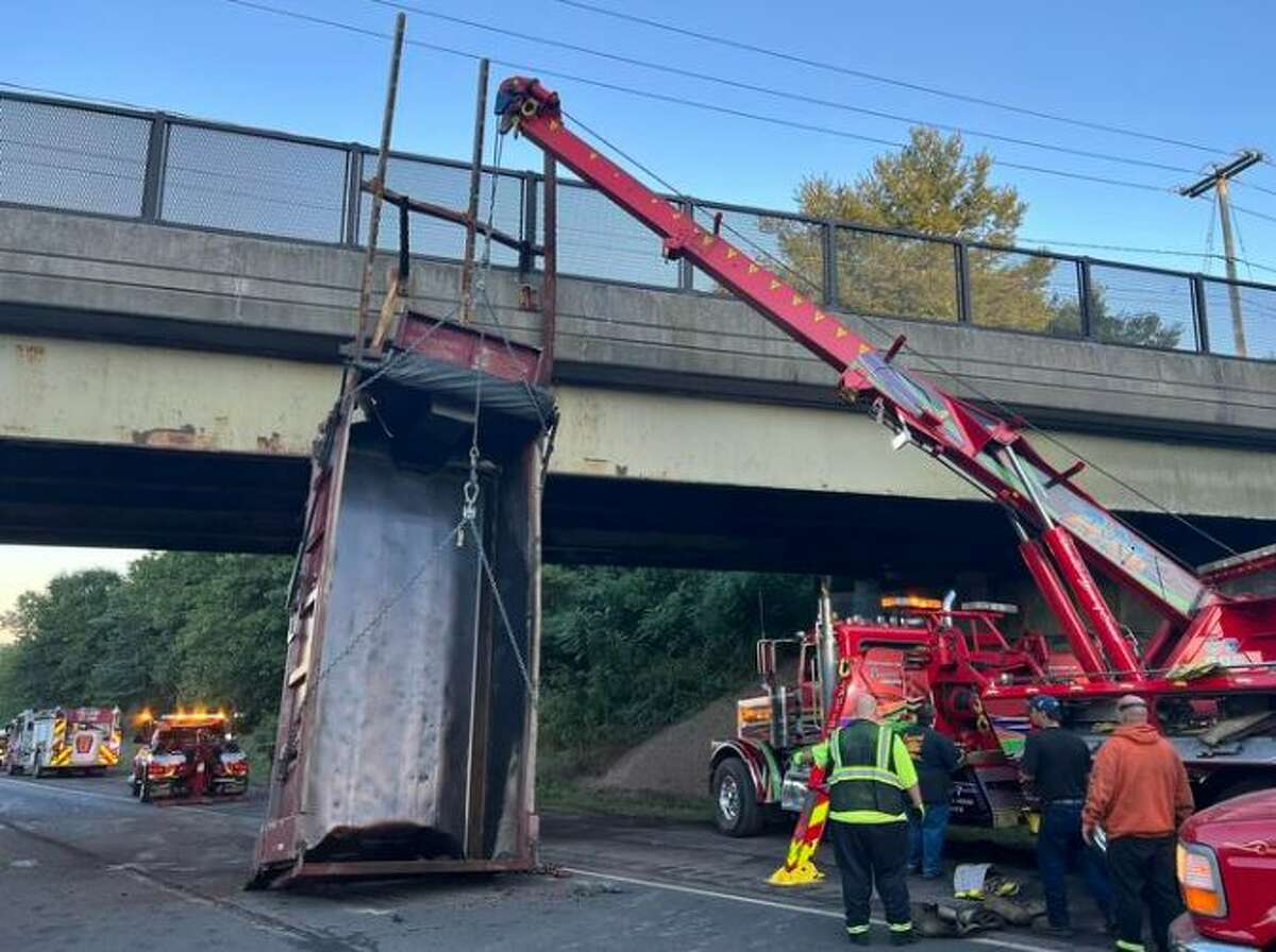 A dump truck driver whose raised bed stuck an I-84 overpass in Tolland this week, snarling traffic for hours,  has been given a ticket, state police say. 