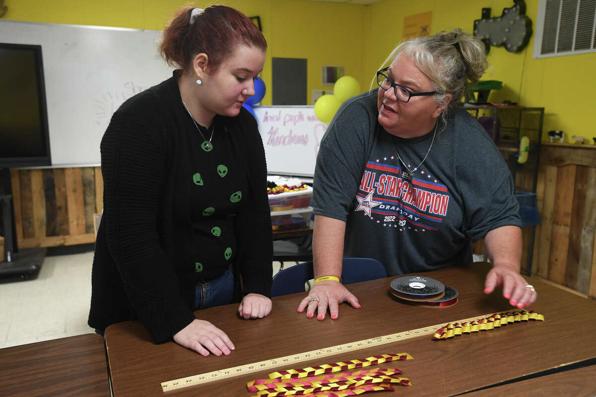 Stephanie Hoppe talks with Breanna Huffman during Friday morning's class making mums for West Brook, Beaumont United and other BISD school homecomings at the Agriculture Science Pavilion Friday. Photo made Friday, September 16, 2022 Kim Brent/Beaumont Enterprise