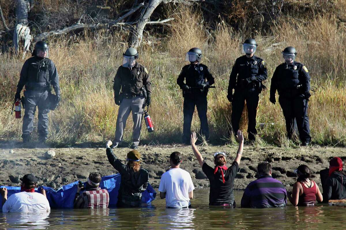 Protesters demonstrating against the expansion of the Dakota Access Pipeline wade in cold creek waters confronting local police, near Cannon Ball, N.D., in 2016.