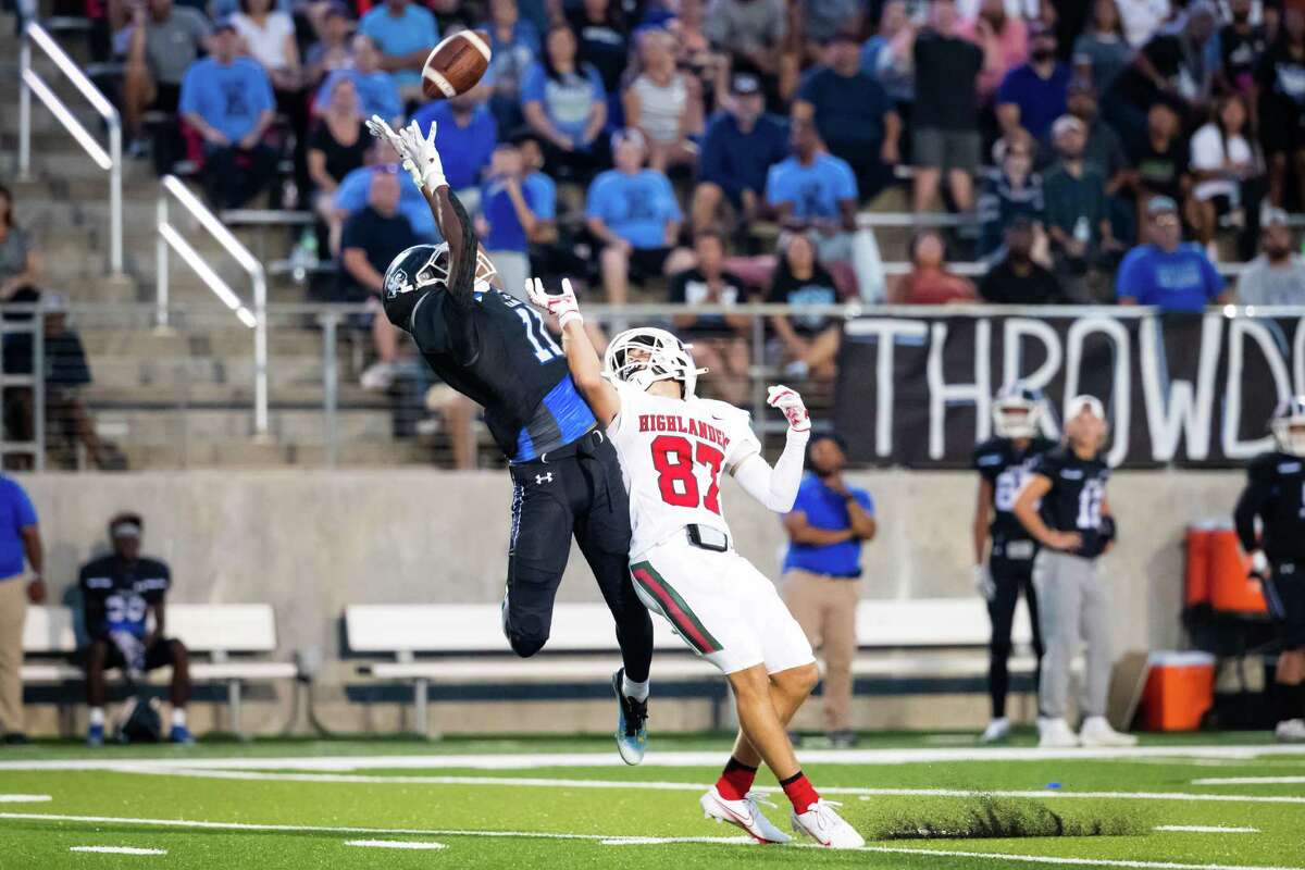 New Caney defensive back CJ Booker (11) attempts to intercept a pass intended for The Woodlands receiver Shane Walker (87) in a district high school football game between The Woodlands and New Caney Friday, Sep 16, 2022, in New Caney.