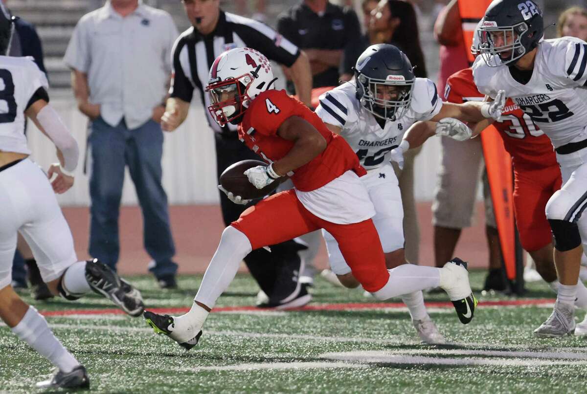 New Braunfels Canyon’s Xavion Noland (04) evades Boerne Champion defenders as he runs for a touchdown in the first half during their football game in New Braunfels on Friday, Sept. 16, 2022.