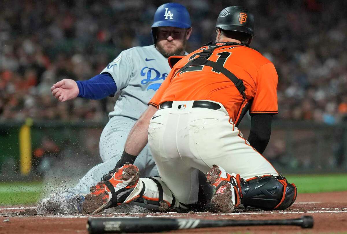 SAN FRANCISCO, CALIFORNIA - SEPTEMBER 16: Max Muncy #13 of the Los Angeles Dodgers sliding at home plate scores as the throw gets past Joey Bart #21 of the San Francisco Giants in the top of the second inning at Oracle Park on September 16, 2022 in San Francisco, California. (Photo by Thearon W. Henderson/Getty Images)