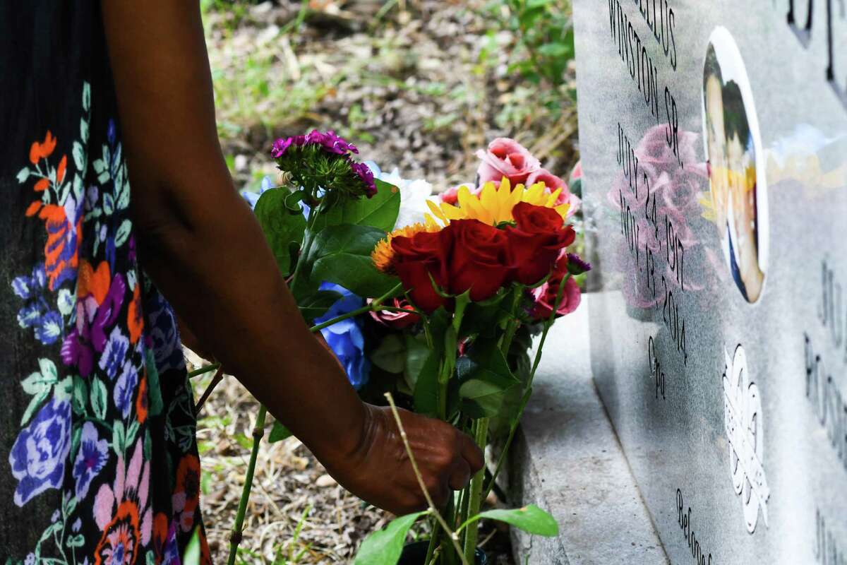 Rosalind Alexander-Kasparik places flowers on her fathers gave. The Alexander’s are fighting subdivision developer encroachment and efforts by the Texas Department of Transportation to expand U.S. Highway 183 through their ancestral land under eminent domain. On Thursday, Jun. 16, 2022 in Pilot Knob, TX.