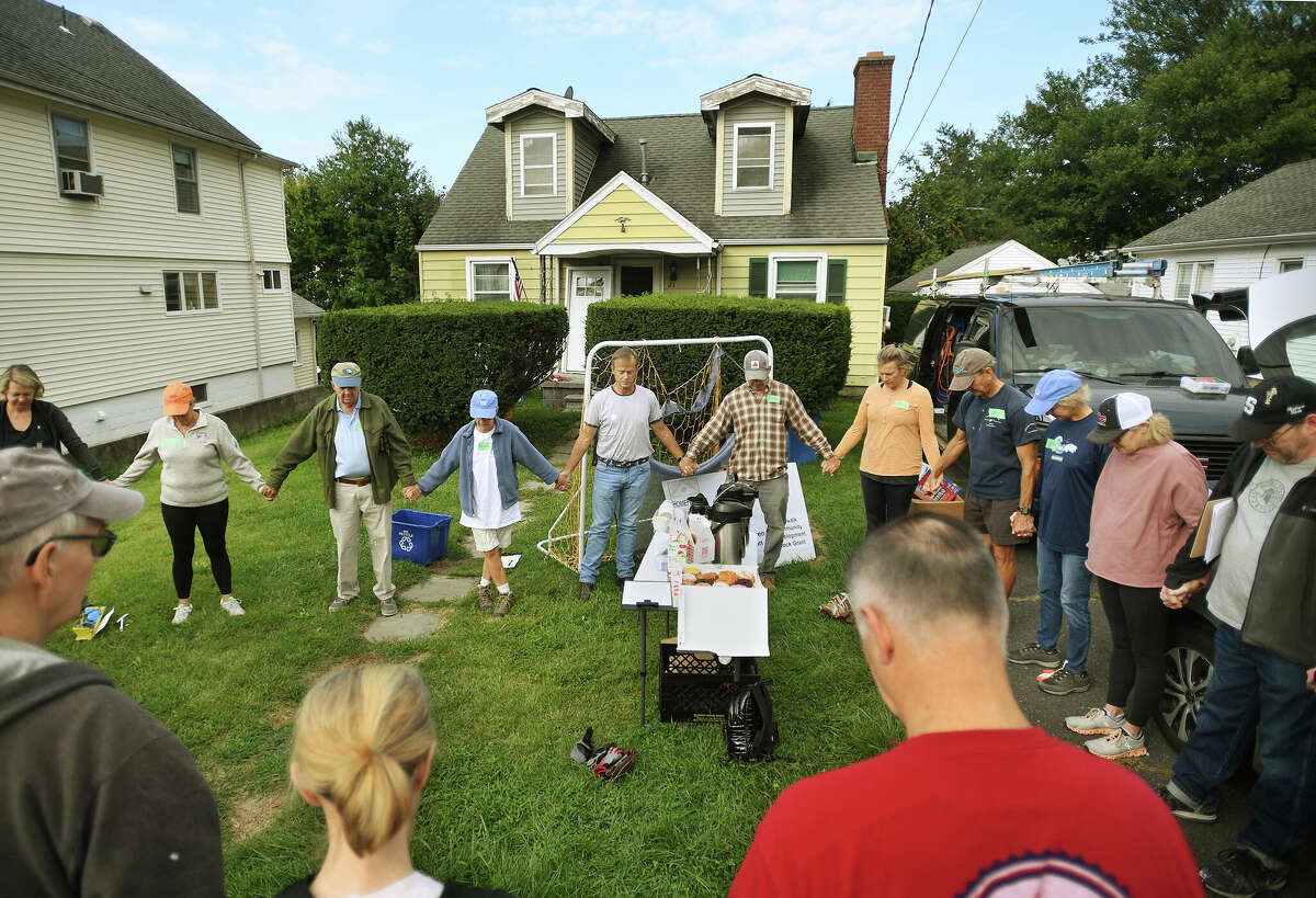 Congregational Church of New Canaan members share in a group prayer before beginning work as part of a HomeFront's third annual Fall HomeFront Days at a home on Magnolia Avenue in Norwalk, Conn. on Saturday, September 17, 2022.
