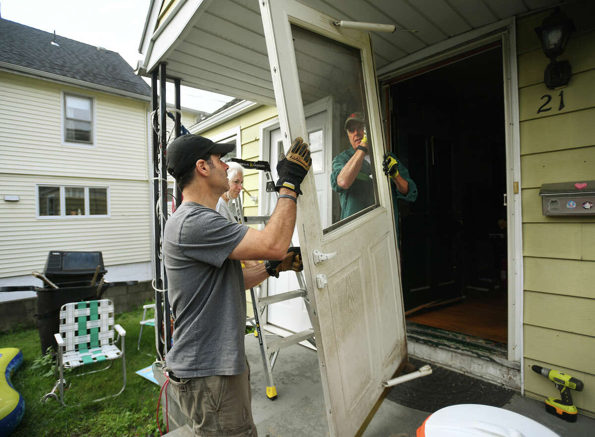 From left; Congregational Church of New Canaan members Tom Herman, Wendy Cassell, and Paul Foley install a new front door as part of a HomeFront's third annual Fall HomeFront Days at a home on Magnolia Avenue in Norwalk, Conn. on Saturday, September 17, 2022.